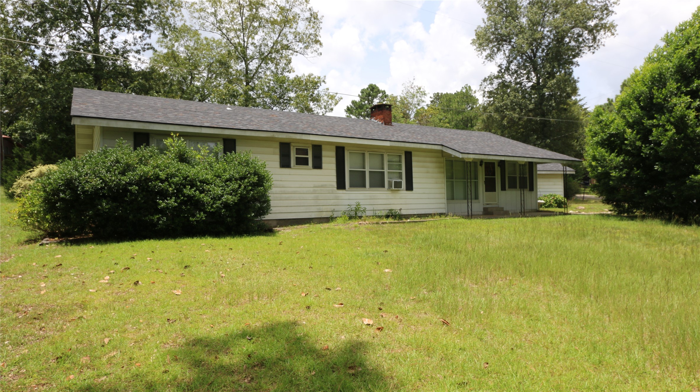 a front view of a house with yard and green space