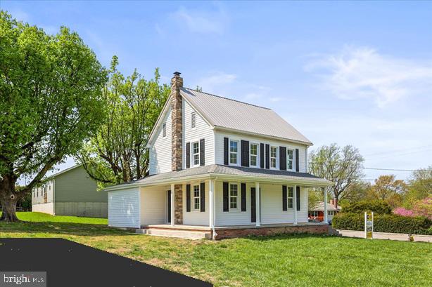 a view of a white house with a big yard and large trees