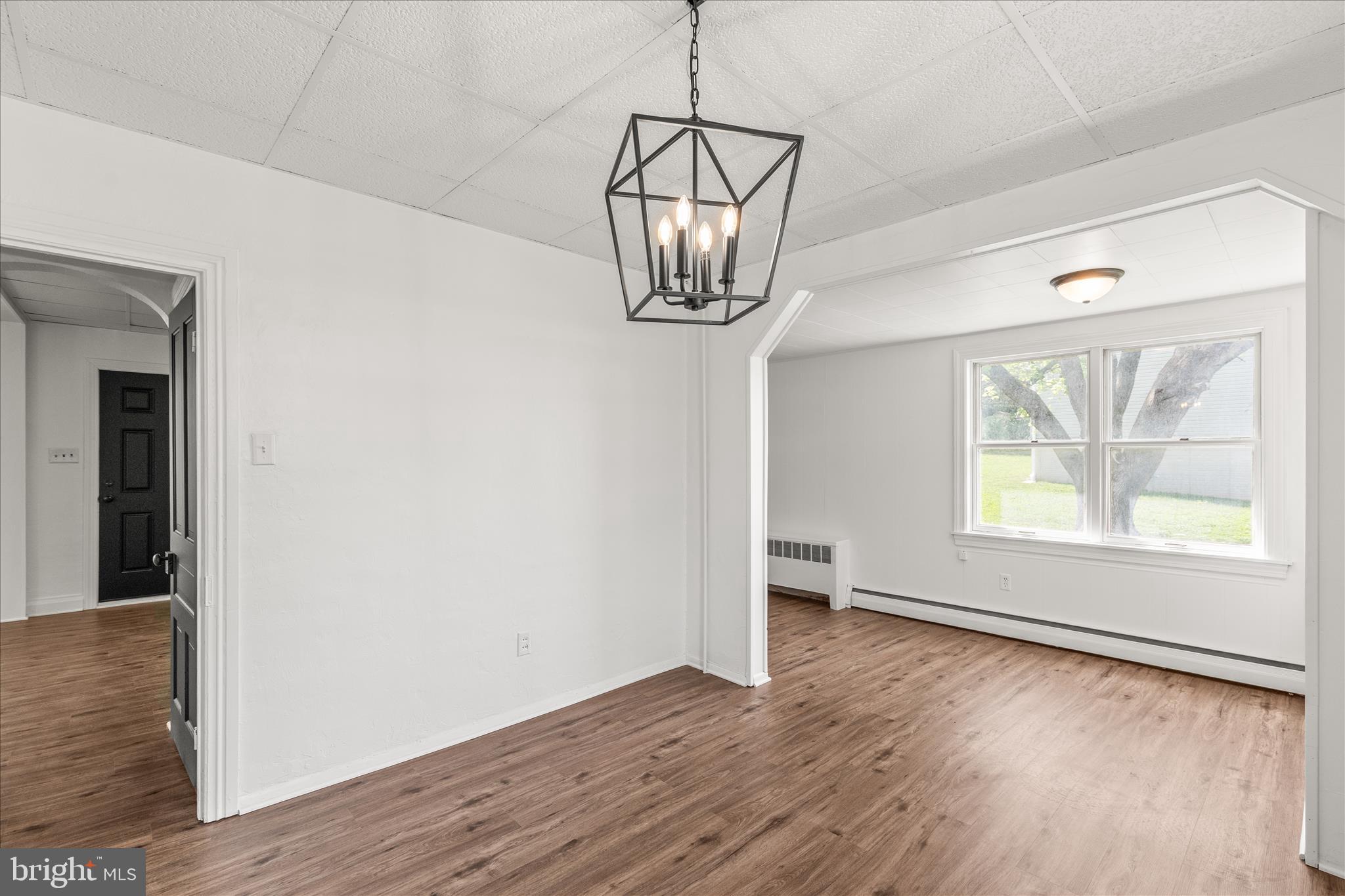 310 Clover Lane Hanover, PA 17331 - Photo 13 of 34 an empty room with wooden floor chandelier and windows
