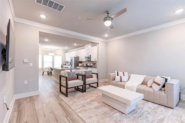 a living room with furniture and a wooden floor
