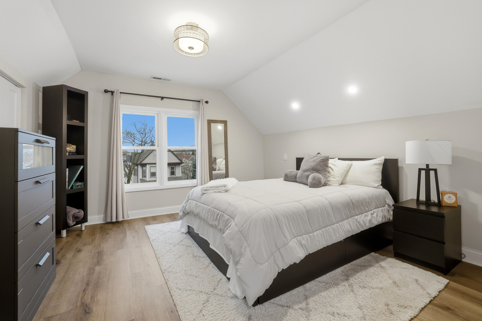 4327 North Avers Avenue Chicago, IL 60618 - Photo 29 of 33 a spacious bedroom with a bed and a large mirror