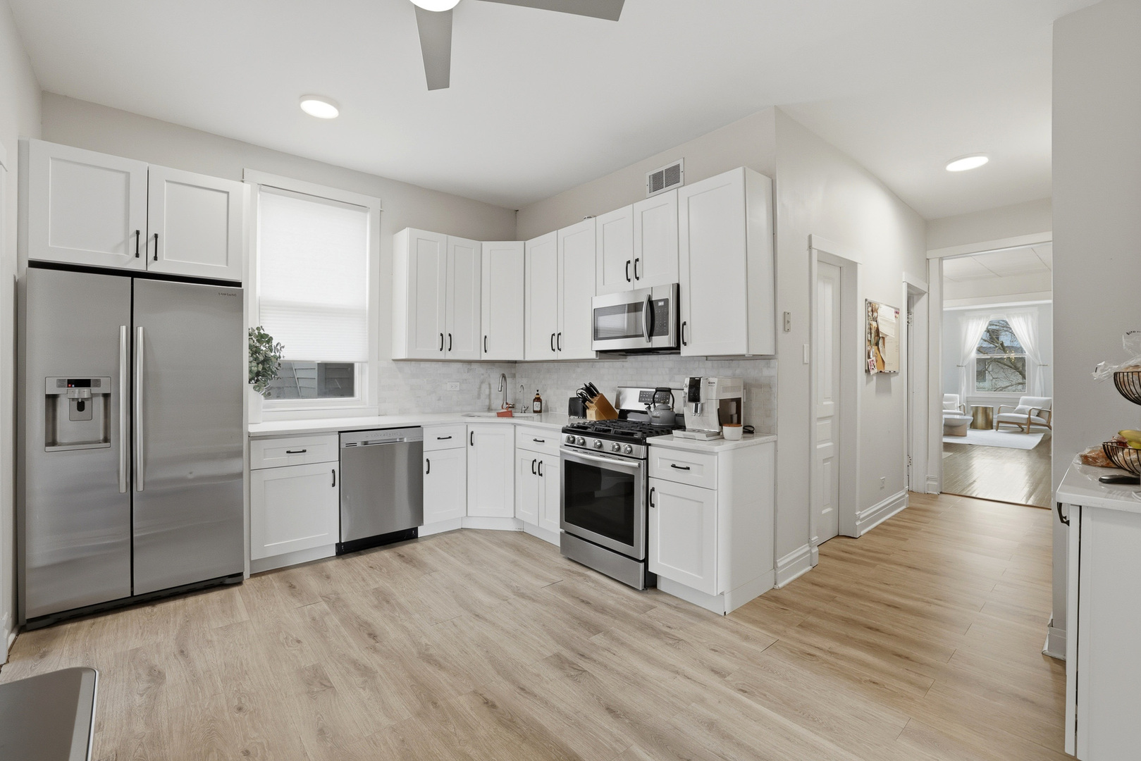 4327 North Avers Avenue Chicago, IL 60618 - Photo 3 of 33 a kitchen with white cabinets and stainless steel appliances