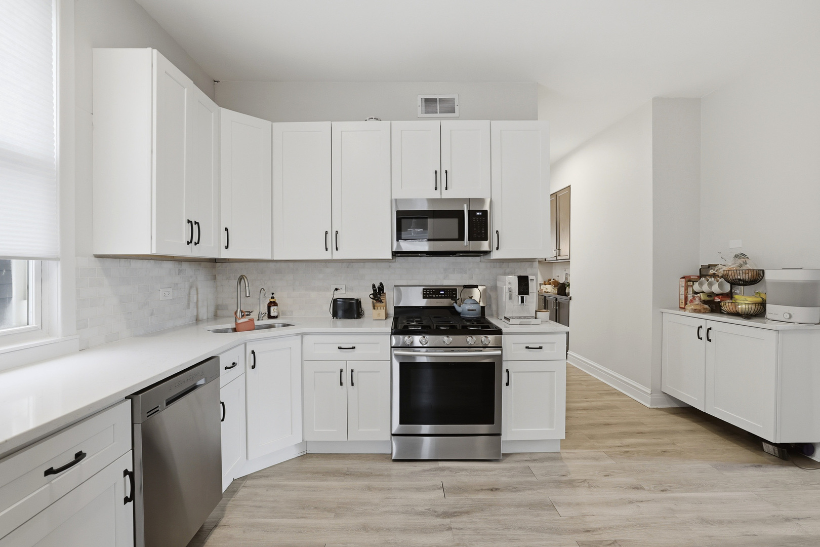 4327 North Avers Avenue Chicago, IL 60618 - Photo 4 of 33 a kitchen with stainless steel appliances granite countertop a stove top oven a sink dishwasher and a refrigerator with wooden cabinets