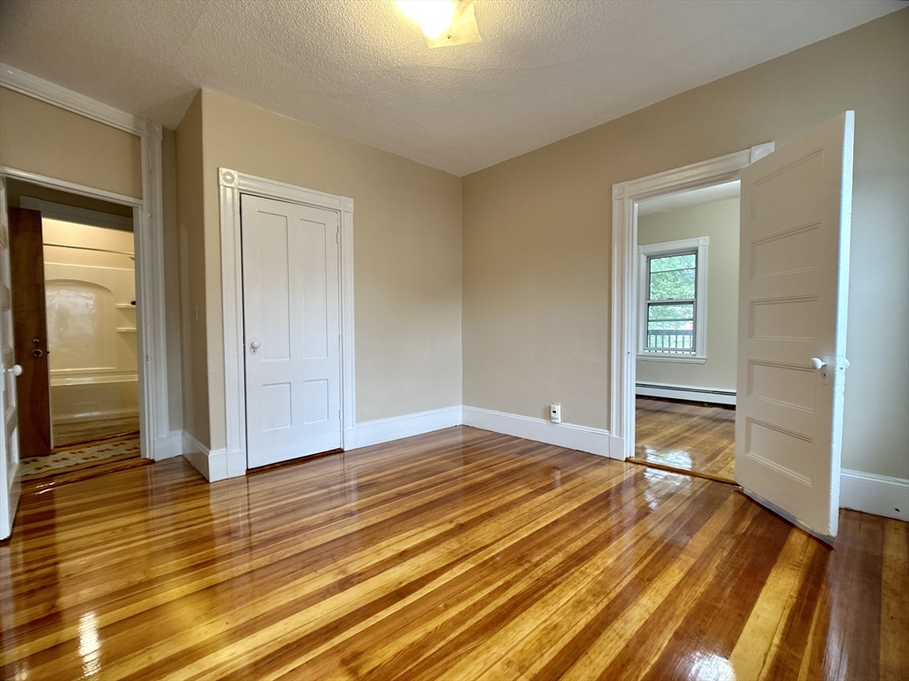 22 Spring Park Avenue, Unit 3 Boston, MA 02130 - Photo 5 of 11 a view of an empty room with wooden floor and a window