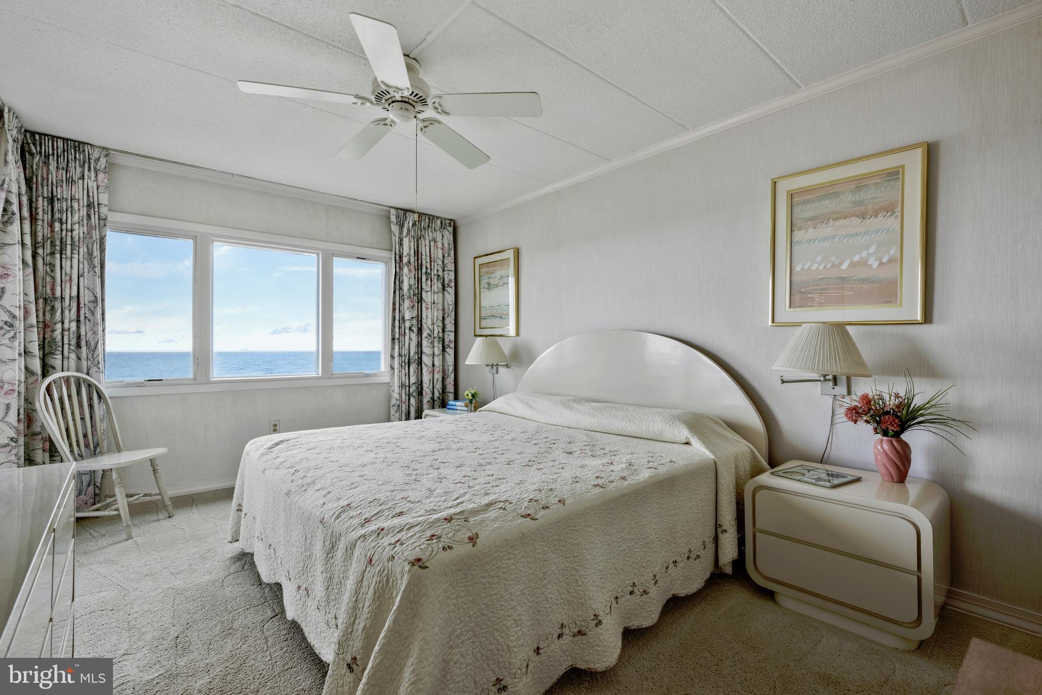 5 77th Street, Unit 404 Ocean City, MD 21842 - Photo 18 of 28 a bedroom with a bed and a chandelier