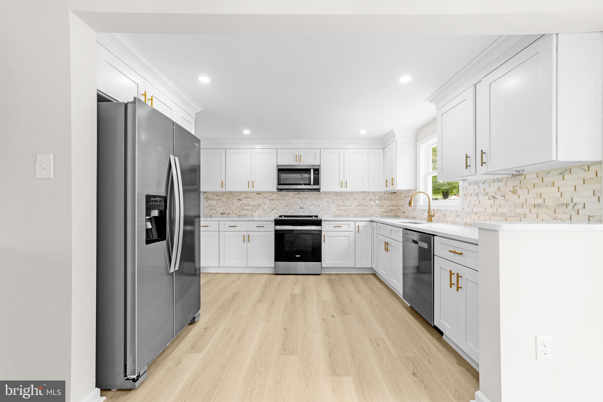 15 Dunlin Way Sicklerville, NJ 08081 - Photo 4 of 28 a kitchen with a refrigerator a sink and a stove top oven