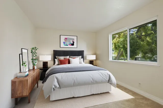 a bedroom with a bed and a painting on the wall