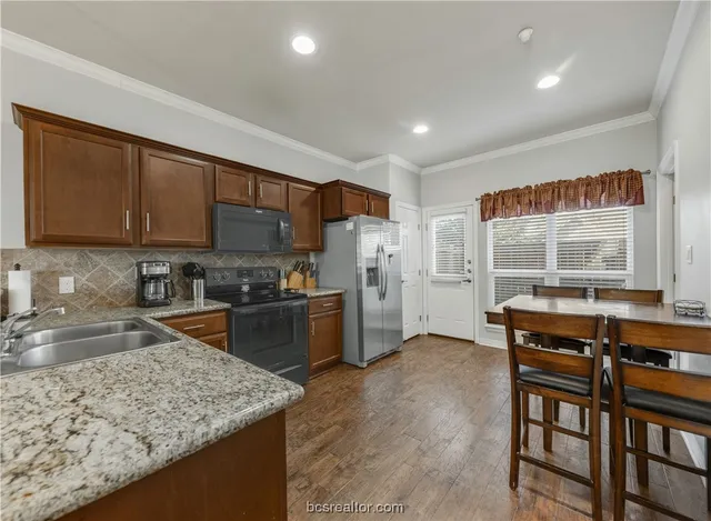 a kitchen with stainless steel appliances granite countertop a stove refrigerator sink and cabinets