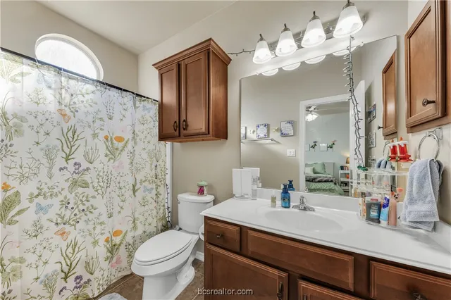 a bathroom with a sink vanity mirror and toilet