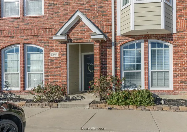 a view of a brick house with potted plants