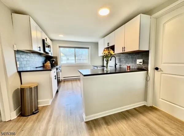 a kitchen with stainless steel appliances granite countertop a refrigerator a sink and a stove