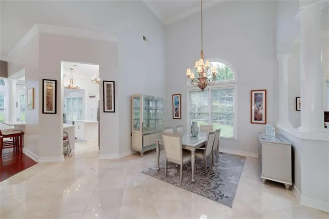 a dining room with chandelier and wooden floor