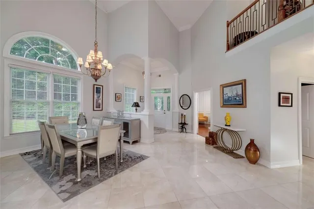 a view of a dining room with furniture a chandelier and wooden floor