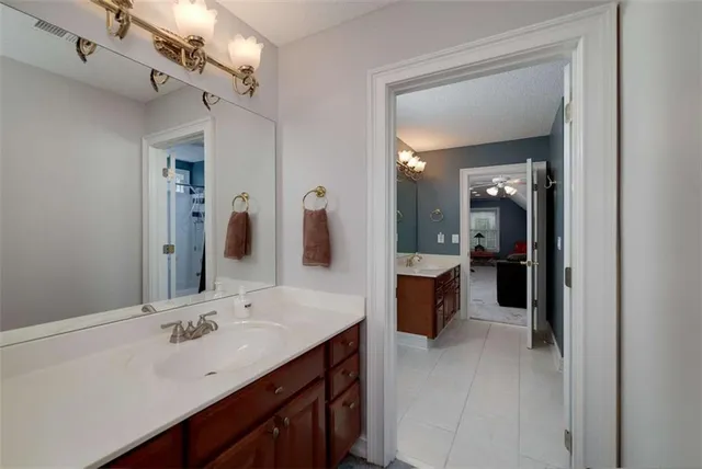 a spacious en suite bathroom with a double vanity sink a mirror and a shower