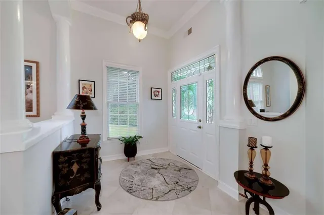 a view of a livingroom with furniture a potted plant and wooden floor