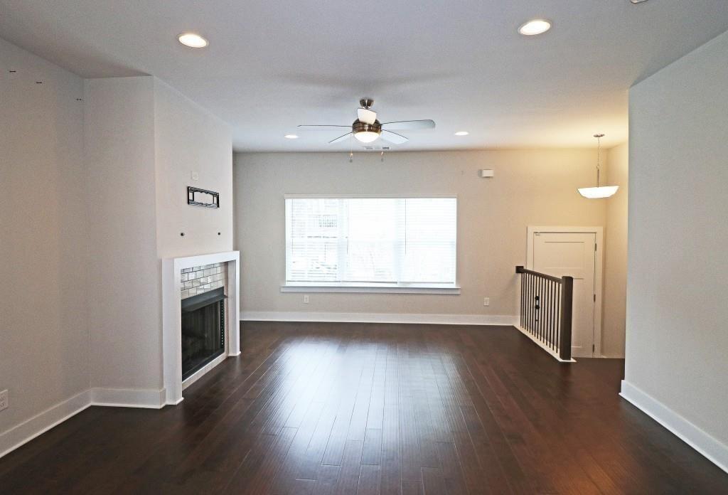 2163 Wiggins Walk Atlanta, GA 30316 - Photo 2 of 22 an empty room with wooden floor fireplace and windows
