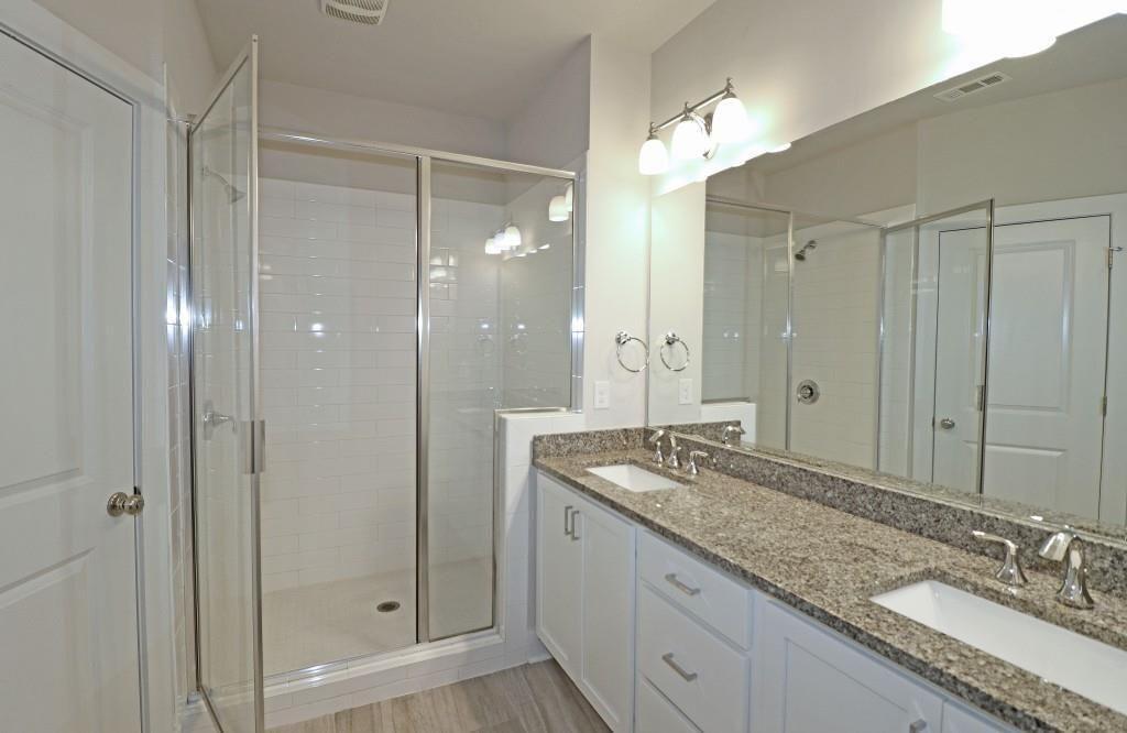 2163 Wiggins Walk Atlanta, GA 30316 - Photo 10 of 22 a bathroom with a granite countertop sink a mirror and a shower