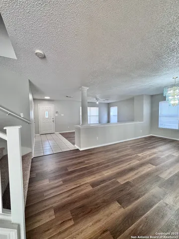 a view of empty room with wooden floor