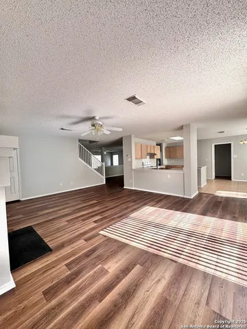a view of a livingroom with wooden floor and a ceiling fan