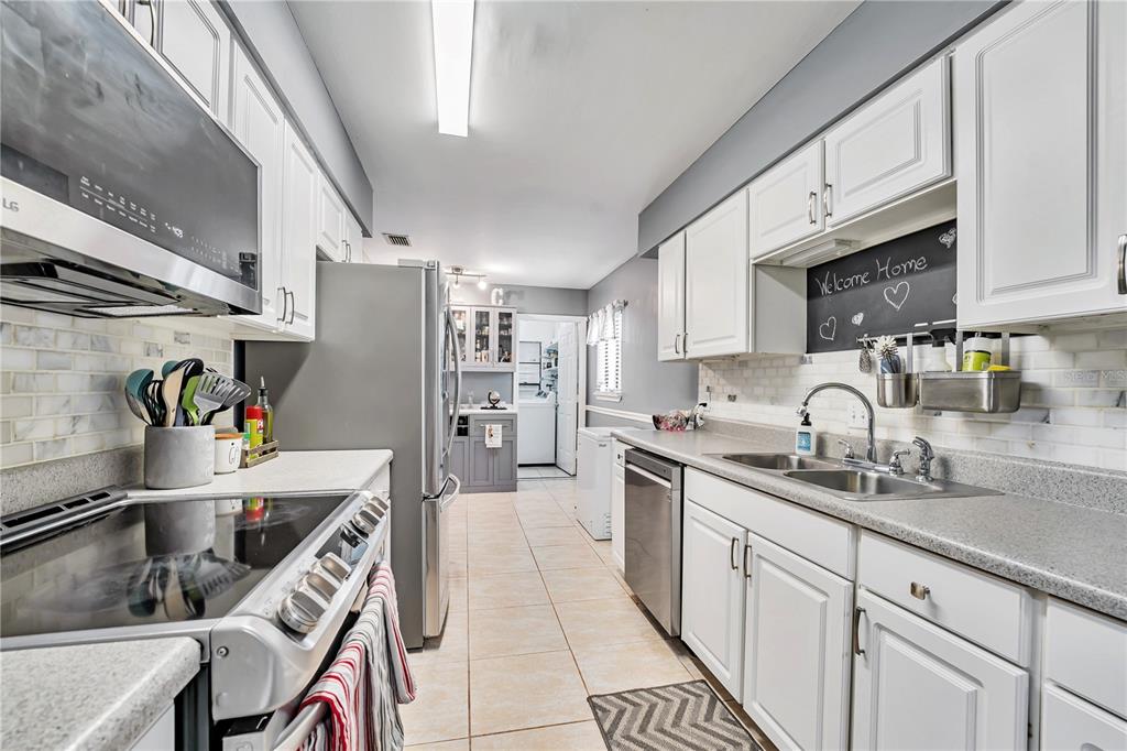 701 St Michael Lane Altamonte Springs, FL 32714 - Photo 5 of 19 a kitchen with granite countertop a sink appliances cabinets and a counter top space