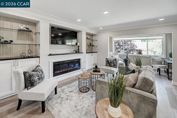 a living room with furniture a large window and a fireplace