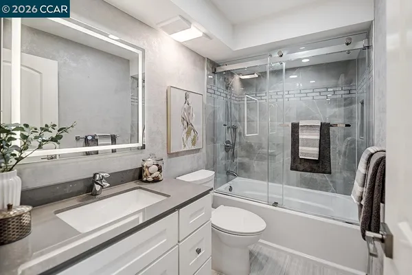 a bathroom with a double vanity sink toilet mirror and bathtub