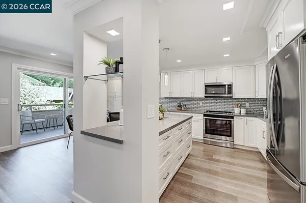 a kitchen with refrigerator cabinets and wooden floor