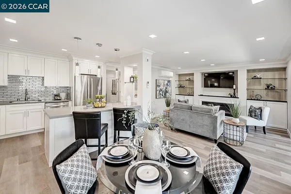 a kitchen with stainless steel appliances kitchen island granite countertop a dining table and chairs
