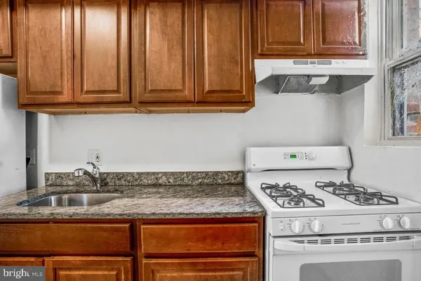 a white stove top oven sitting inside of a kitchen