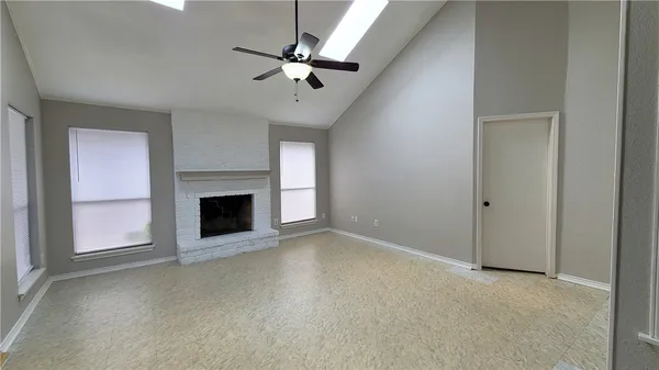 an empty room with fireplace and fan