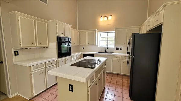 a kitchen with a sink cabinets and refrigerator
