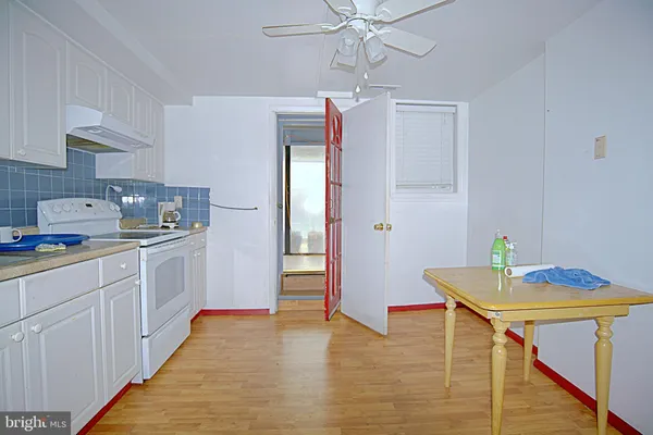 a kitchen with stainless steel appliances a white cabinets and wooden floor