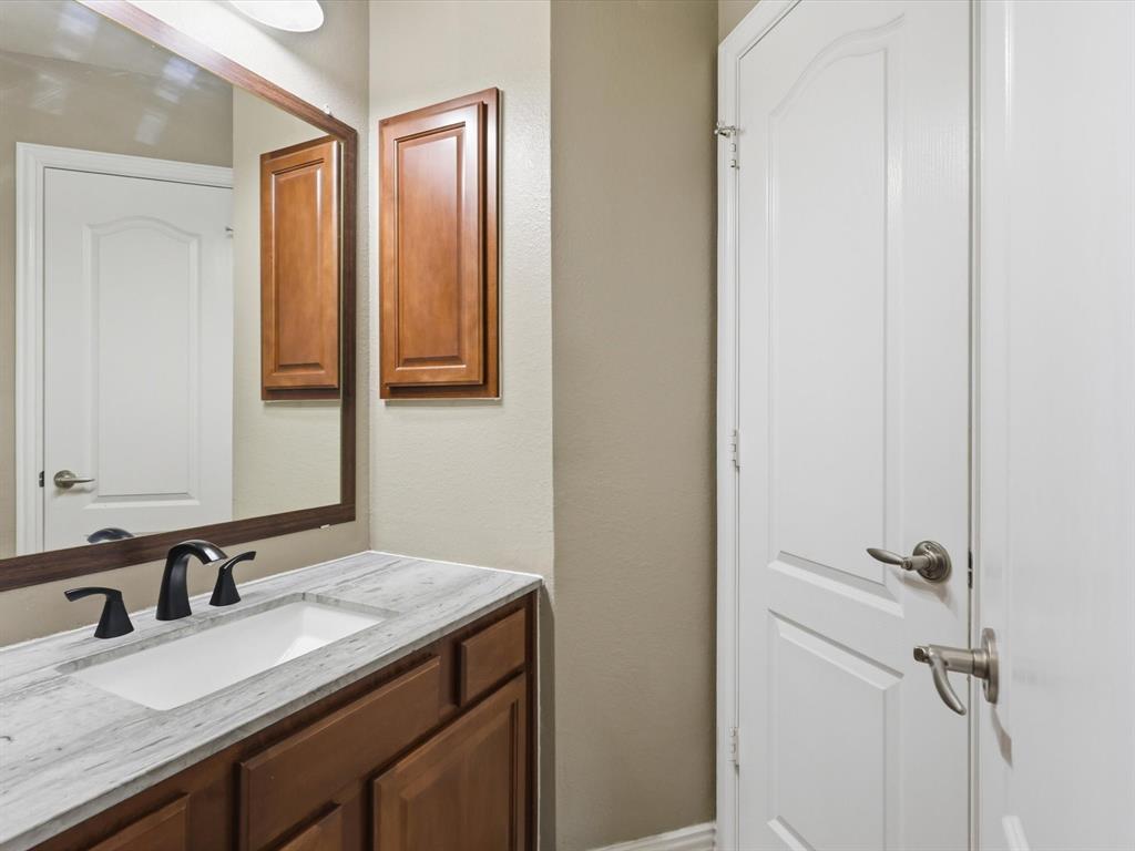 1130 Rio Bravo Way Shady Shores, TX 76208 - Photo 29 of 40 a bathroom with a granite countertop sink and a mirror