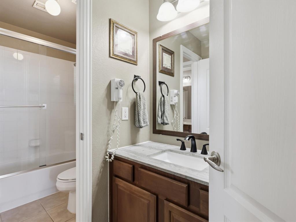 1130 Rio Bravo Way Shady Shores, TX 76208 - Photo 30 of 40 a bathroom with a granite countertop sink toilet and shower