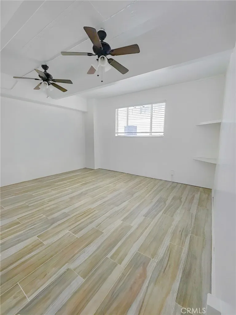 140 Linden Avenue Long Beach, CA 90802 - Photo 4 of 7 a view of a big room with wooden floor ceiling fan and windows