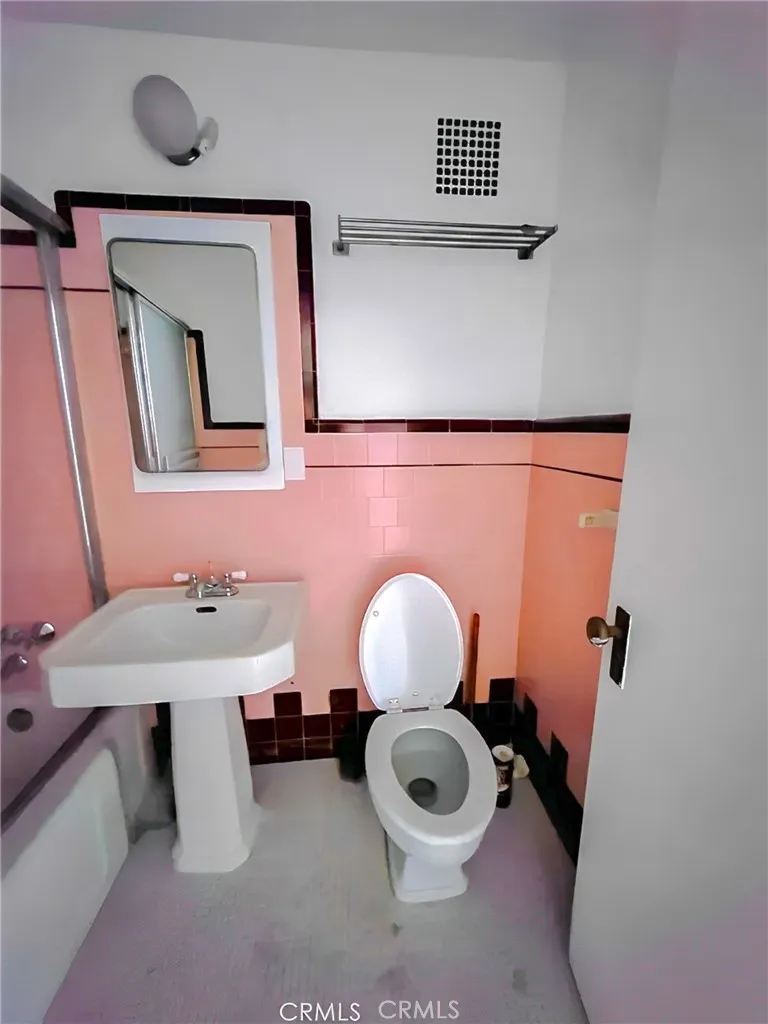 140 Linden Avenue Long Beach, CA 90802 - Photo 6 of 7 a bathroom with a toilet a sink and mirror