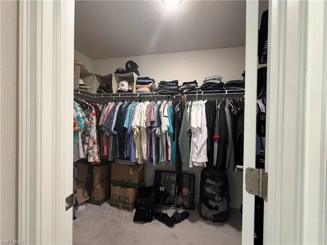 a view of walk in closet with clothes and shoes