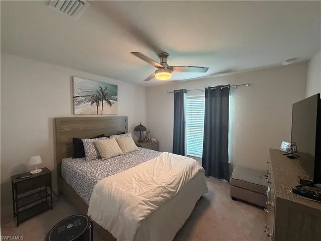 a bedroom with a bed and a tv on the dresser