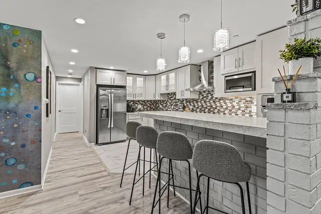 a kitchen with granite countertop white cabinets a sink and white appliances