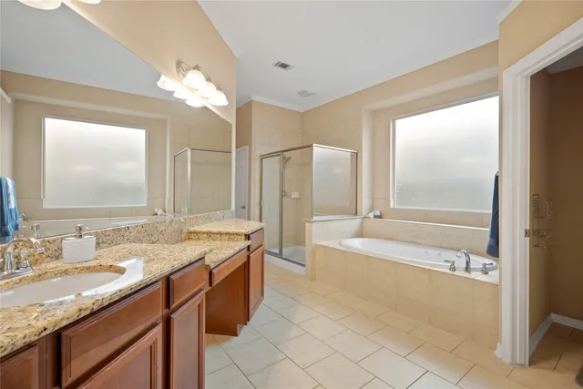 a spacious bathroom with a granite countertop sink a mirror and a bathtub