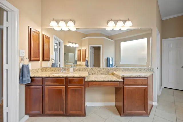 a bathroom with a granite countertop sink a large mirror and a shower