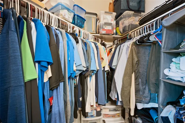 a view of walk in closet with clothes and shoes