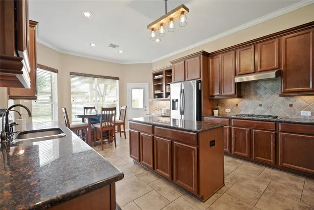 a kitchen with stainless steel appliances granite countertop a sink stove and refrigerator