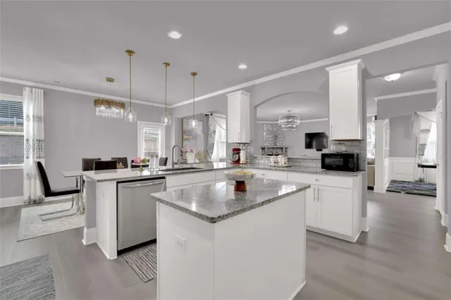 a kitchen with stainless steel appliances granite countertop a sink a stove and a refrigerator