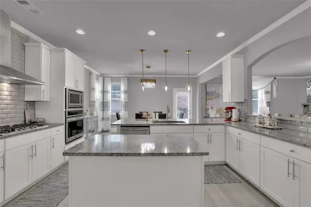 a large kitchen with granite countertop lots of counter space and a sink