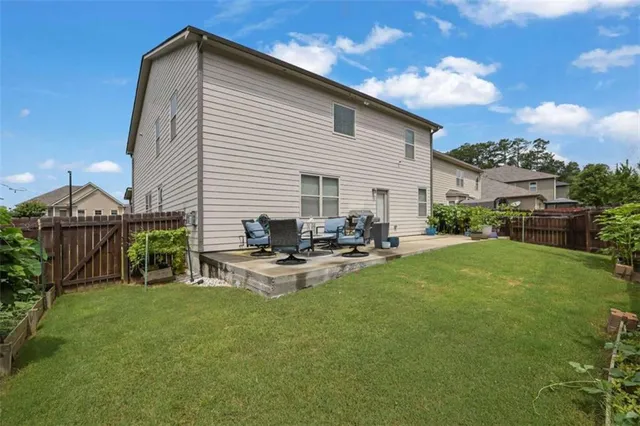 a view of a house with backyard and sitting area