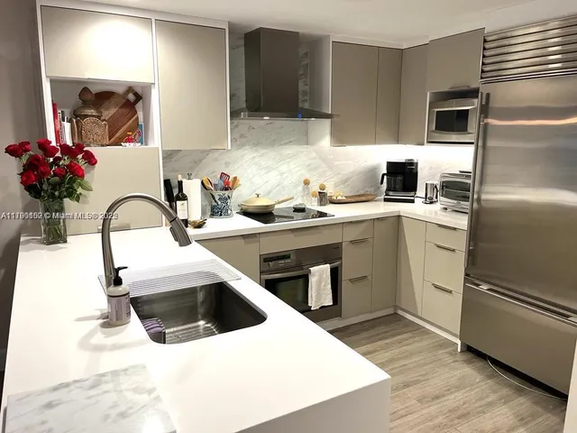 a kitchen with a sink stainless steel appliances and cabinets