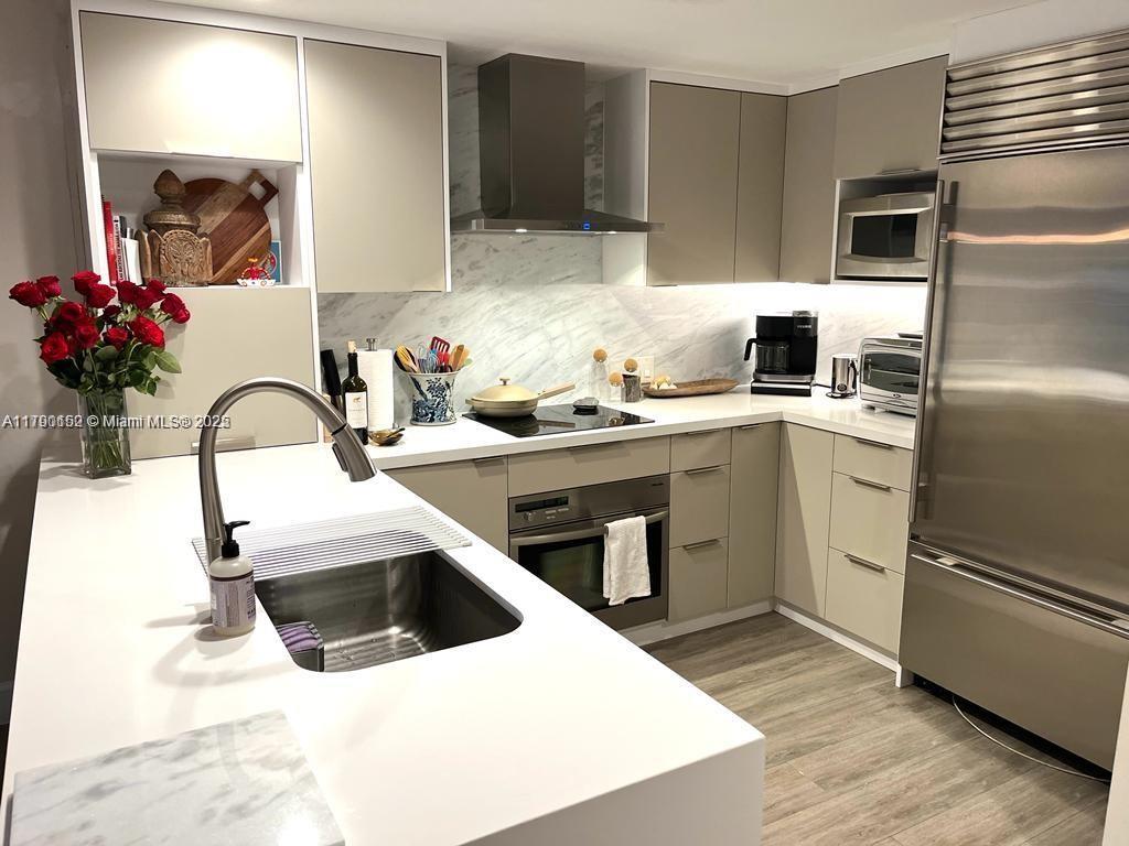 3540 Main Highway, Unit 204 Miami, FL 33133 - Photo 5 of 9 a kitchen with a sink stainless steel appliances and cabinets
