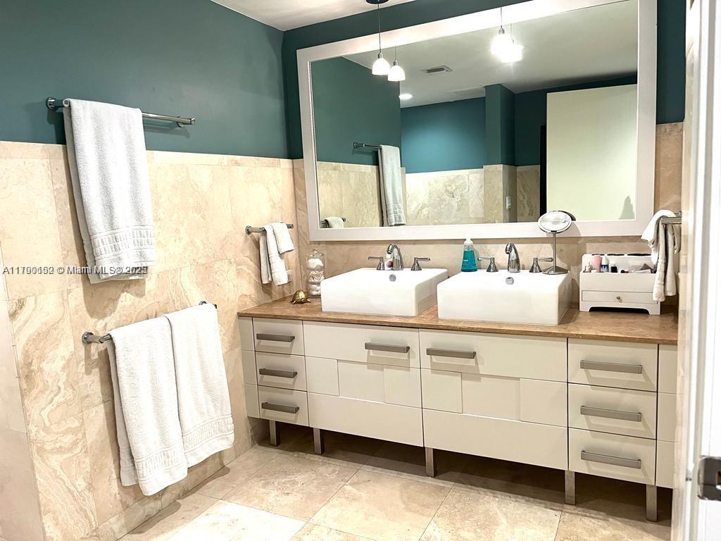 3540 Main Highway, Unit 204 Miami, FL 33133 - Photo 7 of 9 a bathroom with a double vanity sink mirror and