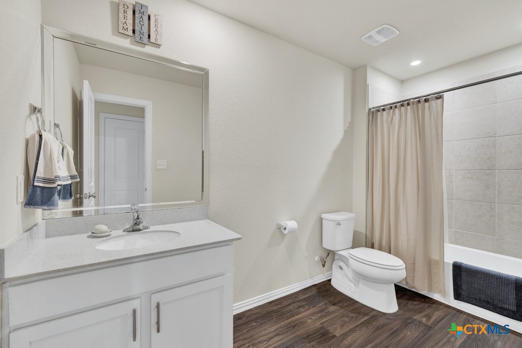 1444 Harwell Loop Kyle, TX 78640 - Photo 28 of 37 a bathroom with a toilet a sink and mirror